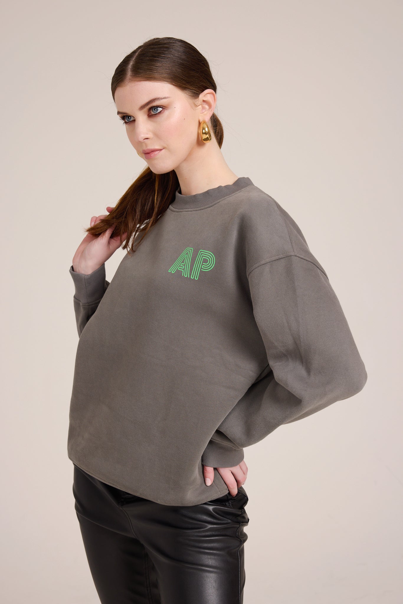 Oversized clear cozy dark grey sweater with small neon green AP logo on the front, plain on the back