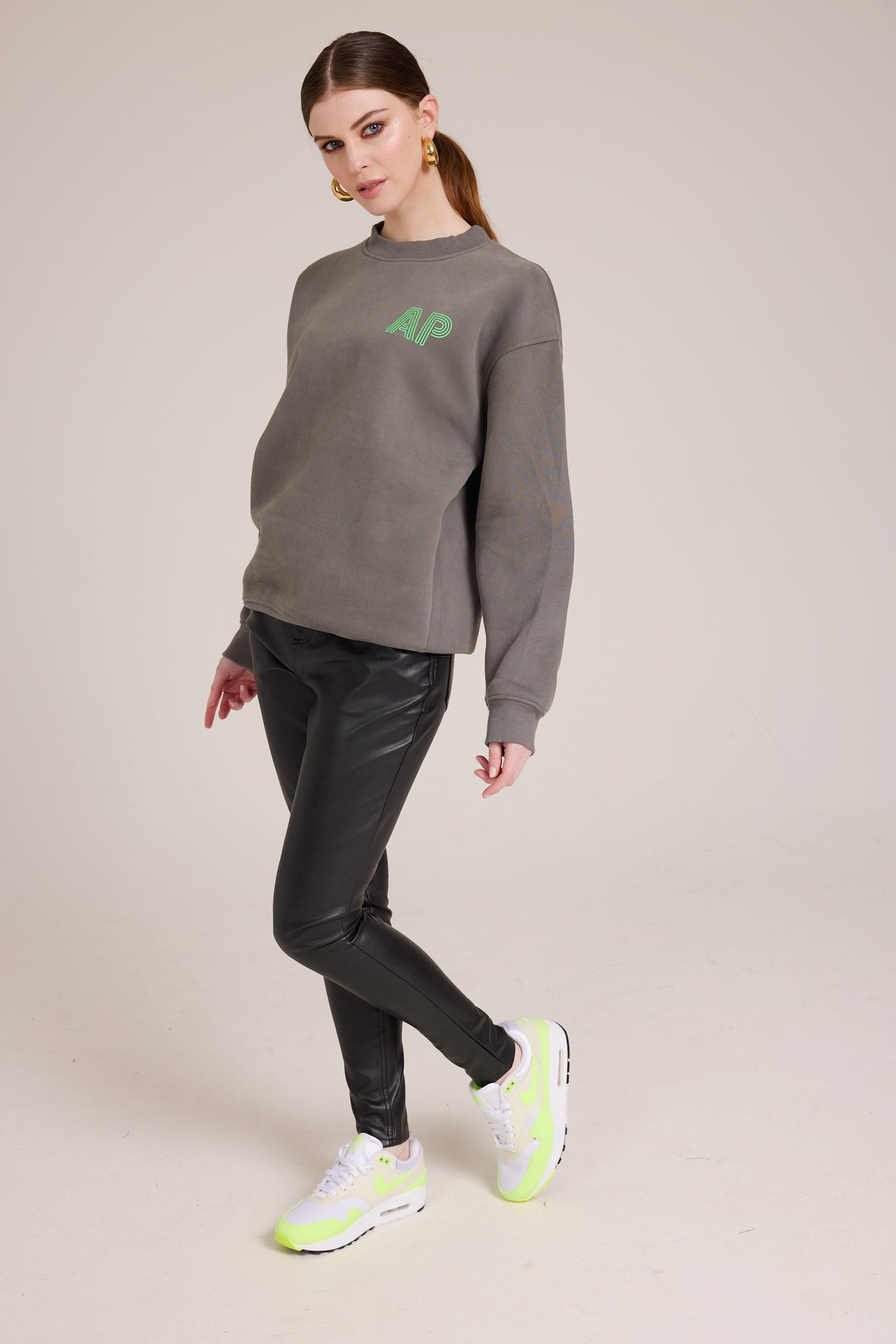 Oversized clear cozy dark grey sweater with small neon green AP logo on the front, plain on the back